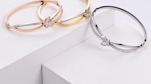 Detailed view of butterfly bangles in gold, silver, and rose gold with shell inlays