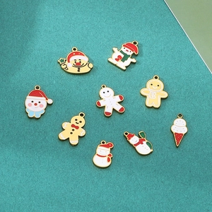 Christmas DIY enamel pendants with snowman and gingerbread man designs on teal background