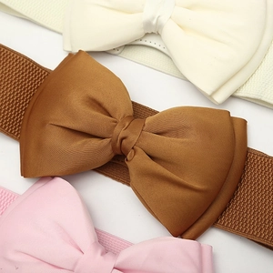 Detail view of elastic waist belts featuring glossy satin bows in brown, ivory, and pink