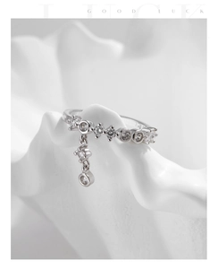 Macro detail of S925 silver ring with geometric zircon settings and dangling star charm