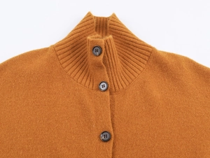 Détail d'un cardigan en tricot kaki avec col montant et boutons ronds foncés élégants