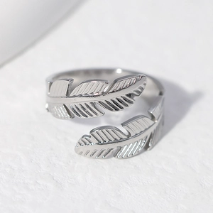 Adjustable silver feather ring in stainless steel with detailed plume texture on white base