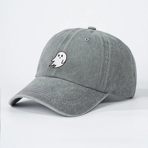 Detail of grey washed denim baseball cap with white ghost embroidery and vintage texture