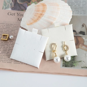 Elegant gold ribbon knot pearl earrings with crystals on jewelry display card
