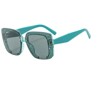 Gafas de sol retro sin montura con montura verde azulado y texturas moteadas negras