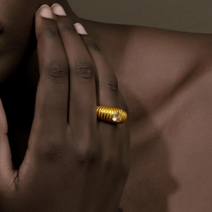 Close-up of 18K gold plated ribbed ring with pear-shaped zircon on finger