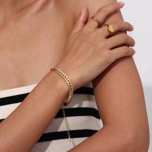 Detail showing 18K gold plated Cuban chain bracelet and Mom engraved heart ring on model