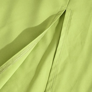 Detailed close-up of stitching and vibrant fruit green fabric on backless dress