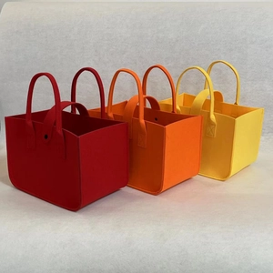 Detailed close-up of vibrant red, orange, and yellow felt tote bags with sturdy handles