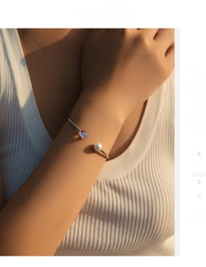 Adjustable S925 sterling silver bangle with moonstone and white pearl detail on wrist