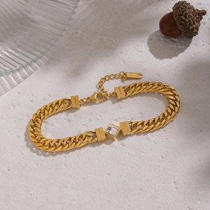 Détail macro du bracelet gourmette plaqué or 18K avec zircon carré et fermoir mousqueton