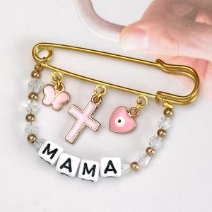 Detailed view of a gold safety pin brooch with MAMA beads and pink butterfly charms
