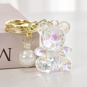Macro shot of a candy-colored iridescent acrylic bear keychain with gold metal hardware