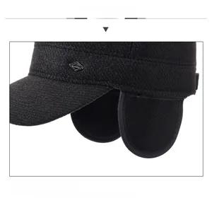Detail view of winter ear flap hat showing warm tweed fabric and metallic logo trim