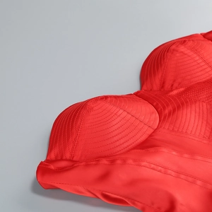 Detailed macro view of the pleated satin bodice and padded cup on red evening dress