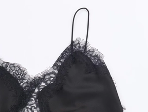 Nahaufnahme eines schwarzen Satin-Tops mit feiner Wimpernspitze und dünnen Trägern