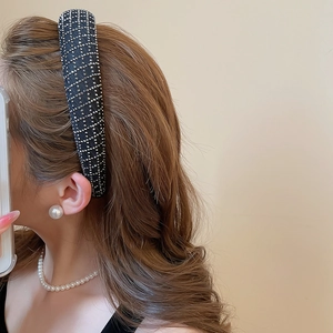 Close-up of elegant black fabric headband with sparkling silver rhinestone grid pattern