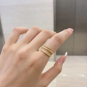 Close-up of golden triple spiral ring with micro-pave zircons worn on model's hand