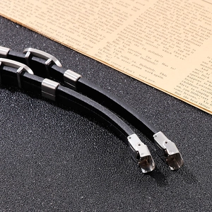 Détail d'un bracelet en cuir noir tressé multicouche avec fermoir en acier inoxydable