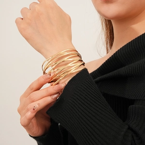 Close-up of layered golden multi-ring bracelet on model wrist with modern minimalist style