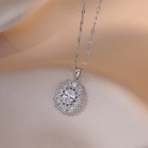 Macro shot of silver flower pendant with zircon stones on champagne silk fabric