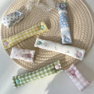 Detail of fabric cable organizers with floral and plaid patterns on a woven mat