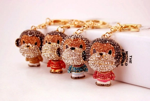 Detail view of colorful rhinestone monkey keychains in gold red blue and pink finishes