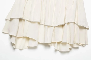 Detail of cream white tiered chiffon skirt with exquisite silver beaded trim edges