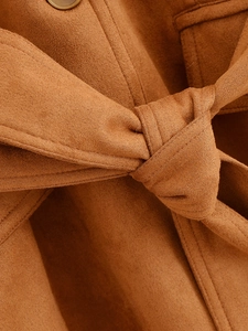 Dettaglio della texture in finto scamosciato marrone caldo con bottone e cintura in vita