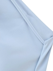 Detailed close-up of light blue satin fabric with precision stitching and fine texture