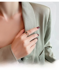 Detail of 18K gold-plated double-layer ring featuring an emerald green gemstone and pavé diamonds