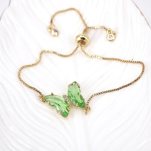 Detail of adjustable gold butterfly bracelet with emerald green crystals and rhinestones
