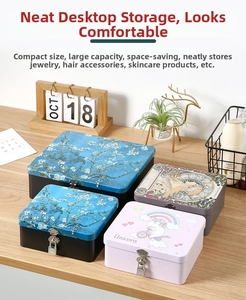 Detail view of vintage tin storage boxes with locks featuring Van Gogh and Mucha art