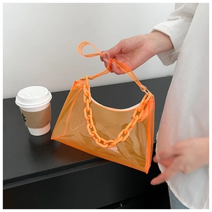 Detail of orange transparent PVC handbag featuring a stylish thick chain and long strap