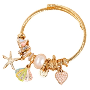 Gold charm bracelet with starfish, shell, pearl and sea turtle pendants on white background