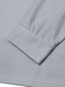 Detailed macro view of gray waffle knit fabric texture and ribbed cuffs on Henley shirt