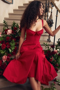 Elegant red vintage strap dress showcased against a romantic rose floral backdrop