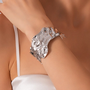 Bracelet manchette argenté avec texture lave irrégulière porté par un mannequin