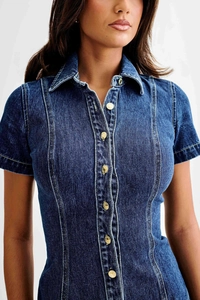 Détails d'une robe en jean bleu foncé avec boutons métalliques et coutures fines