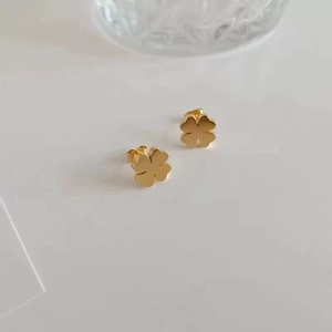Elegant gold-tone four-leaf clover stud earrings crafted from durable titanium steel