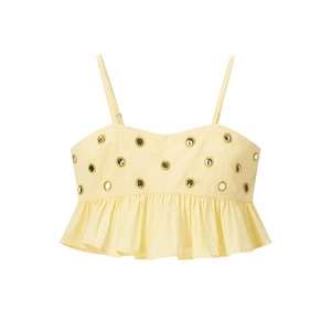 Détail du crop top jaune clair avec œillets métalliques et ourlet à volants
