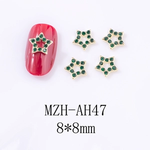 Détail macro de breloques d'ongles étoiles en or 8x8mm avec strass verts pour manucure