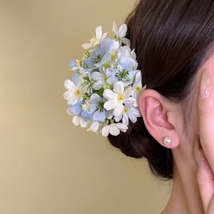 Close-up of blue and white floral hair clip for resort style hair accessories