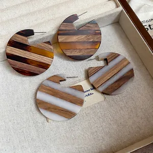 Vintage wooden stud earrings with resin stitching and artistic circular notched design