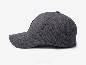 Detailed side view of deep grey herringbone wool baseball cap with windproof ear protection
