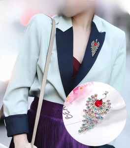 Detail of peacock brooch with colorful rhinestones on a blazer, showing vibrant jewels