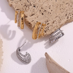 Detailed macro view of triple C-shape rhinestone earrings in gold and silver finish