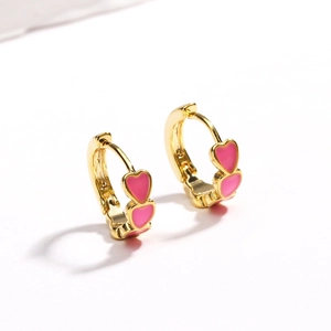 Close-up of golden hoop earrings featuring three continuous pink enamel heart patterns
