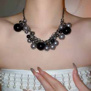 Detail of dark style multi-layer beaded necklace with black pearls on model's neck