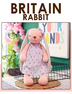 Close-up of pink plush rabbit doll wearing a lavender floral dress and a matching bow